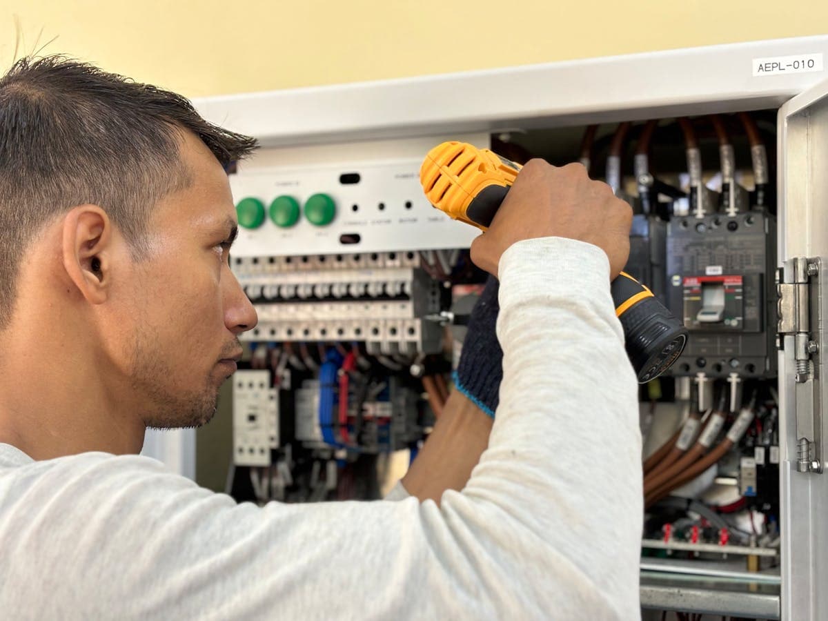Elektriker bei Arbeiten am Schaltkasten — Auftragsstatus im Griff